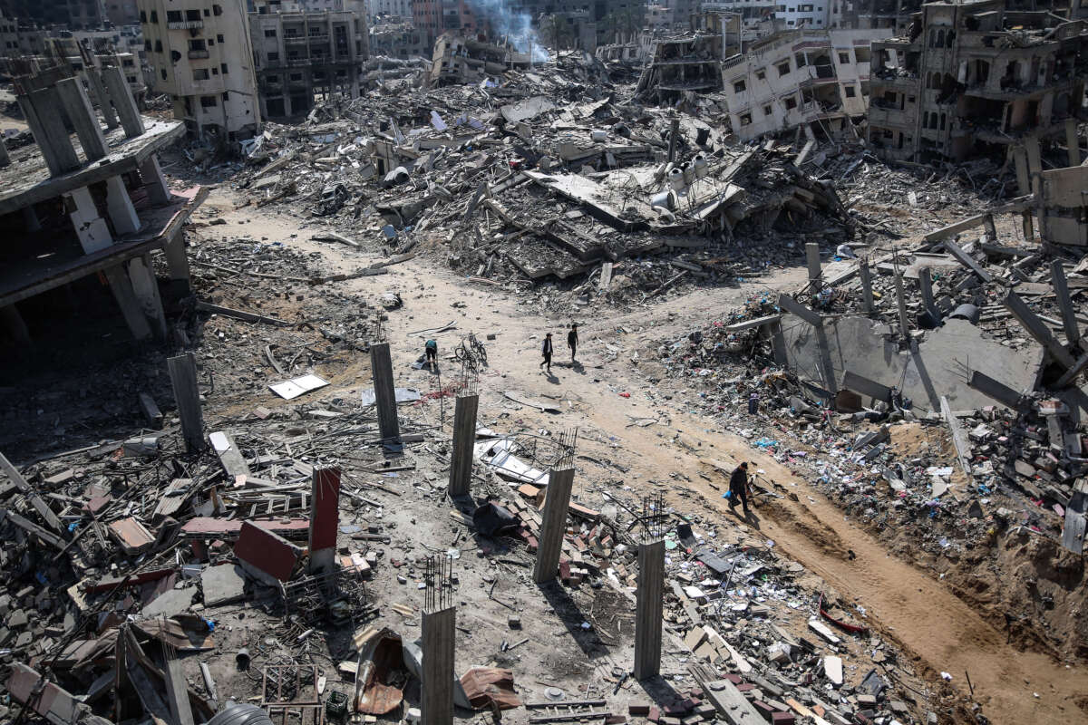 Palestinians walk amid the destruction in the vicinity of al-Shifa Hospital, following a two-week military operation by the Israeli army in Gaza City.