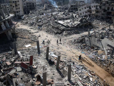 Palestinians walk amid the destruction in the vicinity of al-Shifa Hospital, following a two-week military operation by the Israeli army in Gaza City.