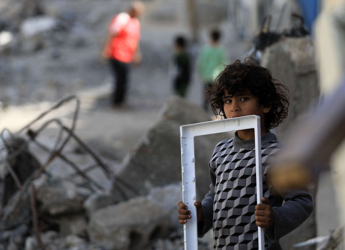 Palestinians, including children, collect their belongings among the rubble of their houses destroyed by Israeli attacks on Al-Jenine neighborhood in Rafah, Gaza, on March 31, 2024.