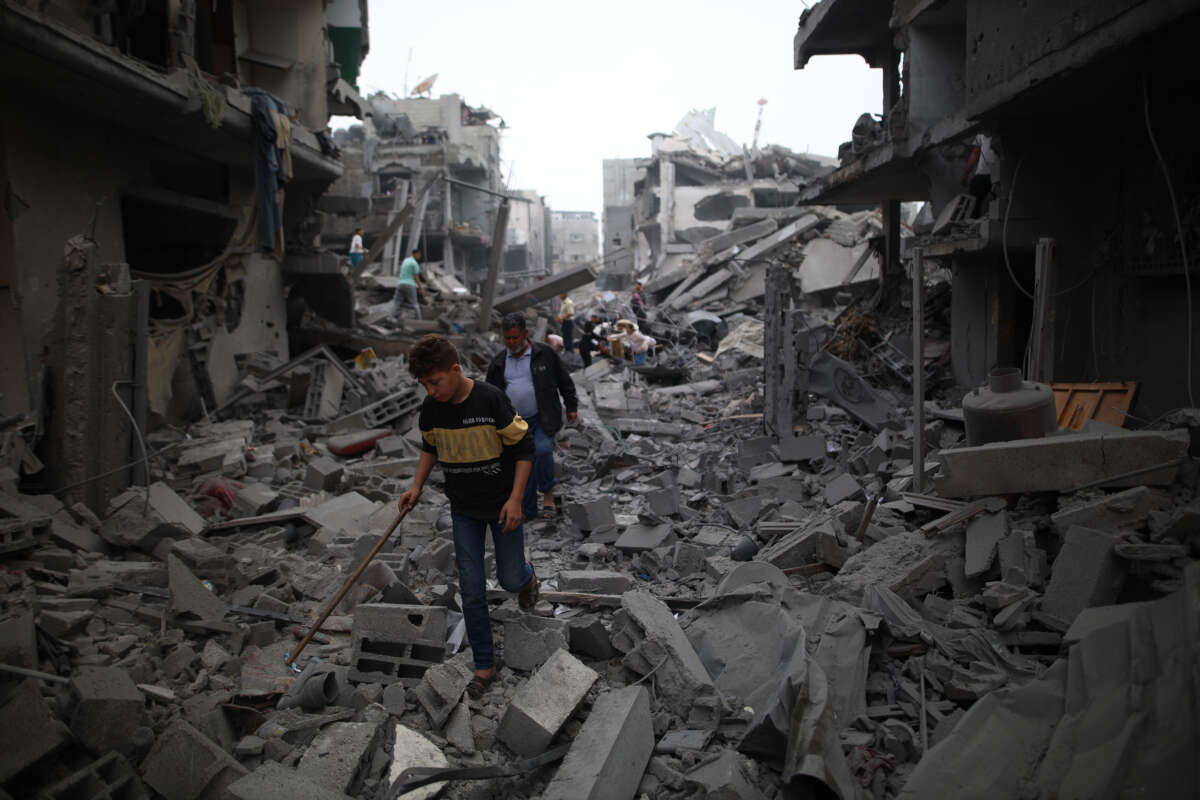 People walk among the rubble of destroyed buildings after an Israeli airstrike in Maghazi refugee camp, central Gaza Strip, on April 4, 2024.