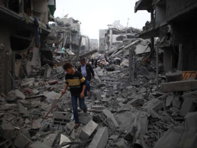 People walk among the rubble of destroyed buildings after an Israeli airstrike in Maghazi refugee camp, central Gaza Strip, on April 4, 2024.