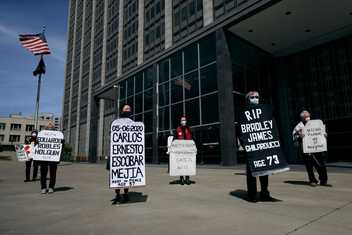 Faith leaders and activists hold signs and tombstone shapes as they hold a public memorial in front of the Phillip Burton Federal Building and U.S. Courthouse to honor victims of COVID-19 that have died while incarcerated, on May 12, 2020, in San Francisco, California.