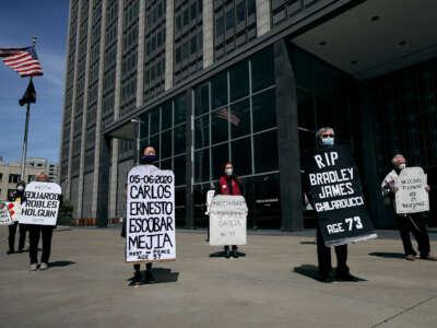 Faith leaders and activists hold signs and tombstone shapes as they hold a public memorial in front of the Phillip Burton Federal Building and U.S. Courthouse to honor victims of COVID-19 that have died while incarcerated, on May 12, 2020, in San Francisco, California.