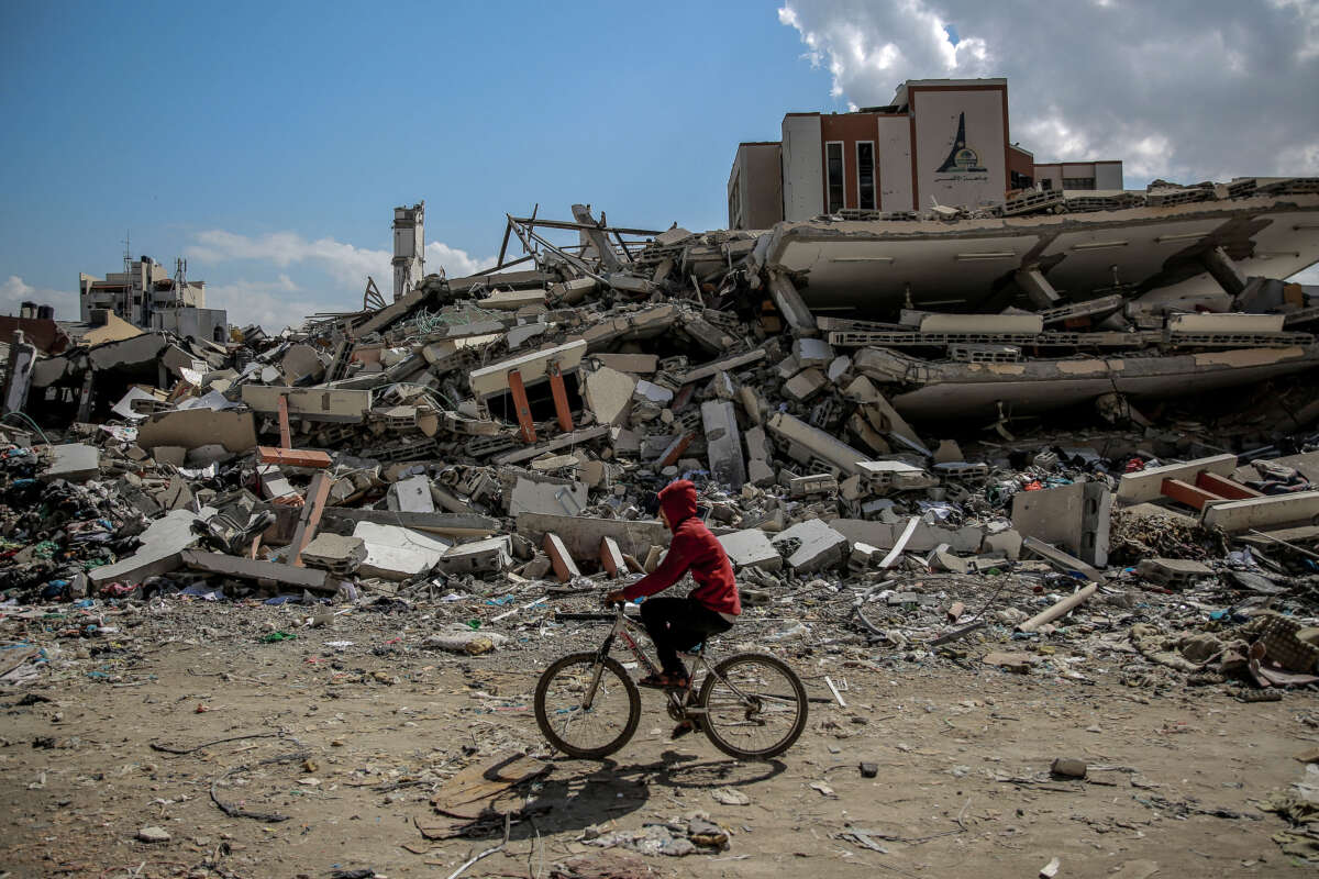 A man rides his bicycle past the al-Aqsa University, leveled by Israeli bombardment in Gaza City on February 15, 2024.