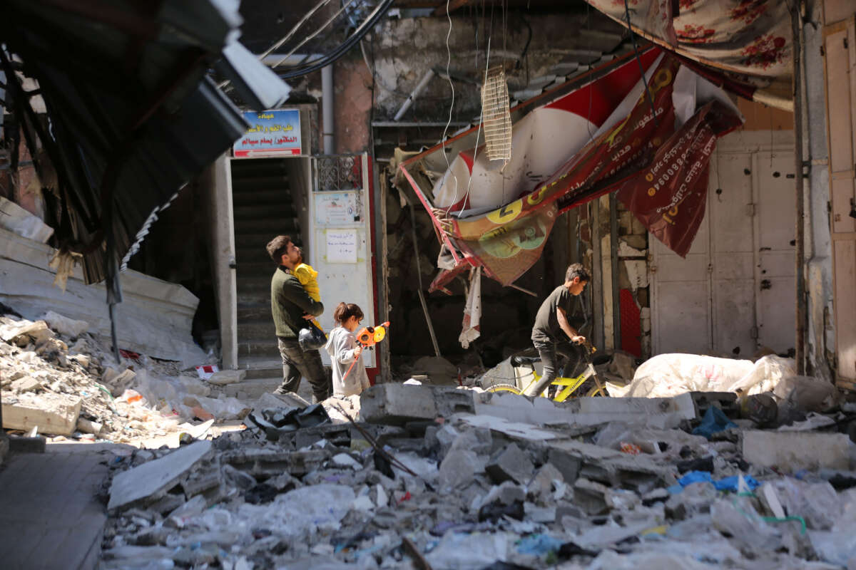 Palestinians engage in holiday shopping within makeshift markets nestled amidst the remnants of buildings ravaged by recent Israeli attacks in Northern Gaza, on April 9, 2024."