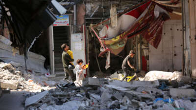 Palestinians engage in holiday shopping within makeshift markets nestled amidst the remnants of buildings ravaged by recent Israeli attacks in Northern Gaza, on April 9, 2024."