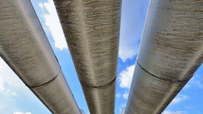 Looking up at pipelines over blue sky