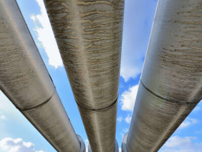 Looking up at pipelines over blue sky