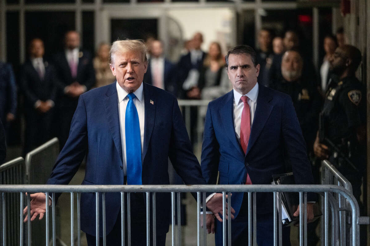 Donald Trump stands next to a man in a suit