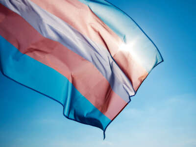 Transgender flag flying over blue sky