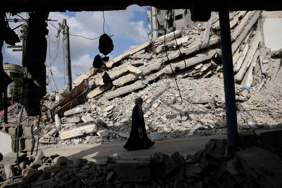 A Palestinian woman walks past the rubble of buildings destroyed in previous Israeli bombardments, in Rafah, in the southern Gaza Strip, on April 30, 2024, amid the ongoing conflict between Israel and the Palestinian militant group Hamas.