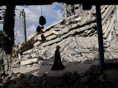 A Palestinian woman walks past the rubble of buildings destroyed in previous Israeli bombardments, in Rafah, in the southern Gaza Strip, on April 30, 2024, amid the ongoing conflict between Israel and the Palestinian militant group Hamas.