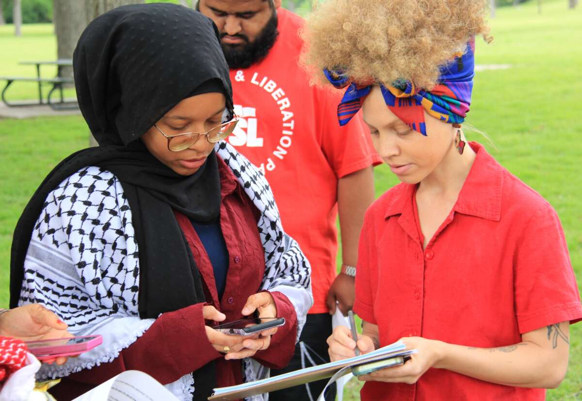 North Dallas resident and organizer Baiyinah Abdullah works with Tamera Hutcherson to pin down her canvassing turf for the day on April 14, 2024 at Glendale Park in Dallas, Texas.