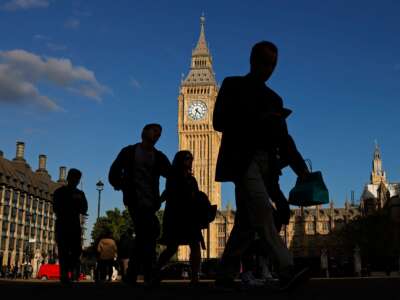 Pedestrians walk past British parliment