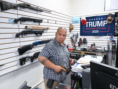 Tunis Lopez, owner of EDC TX gun store, puts on his firearm as the first customer of the day arrives on August 2, 2023, in New Braunfels, Texas.