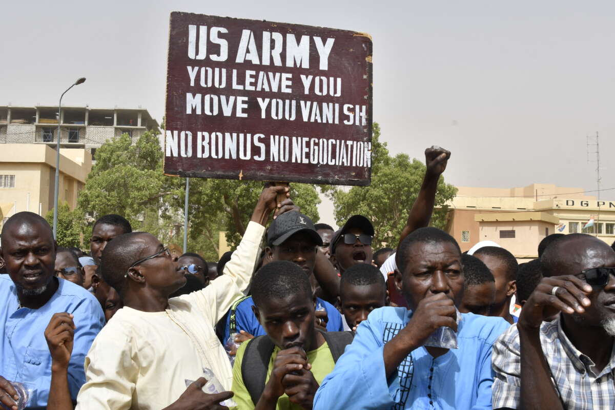 Protesters react as a man holds up a sign demanding that soldiers from the United States Army leave Niger without negotiation during a demonstration in Niamey, Niger, on April 13, 2024.