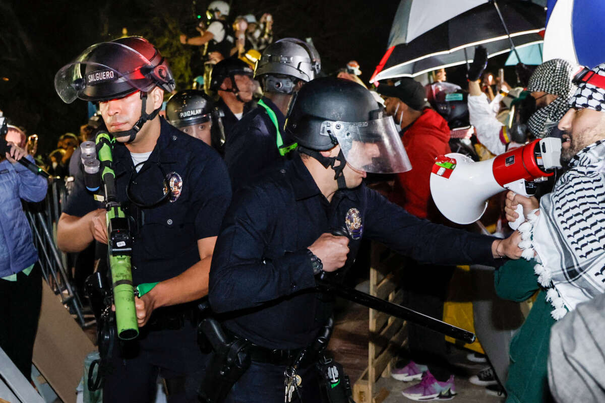 Police react while pro-Palestinian students stand their ground after police breached their encampment at the campus of the University of California, Los Angeles (UCLA) in Los Angeles, California, early on May 2, 2024.