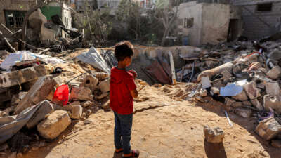 A boy stands before an impact crater at the site of a building that was hit by Israeli bombardment in Rafah in the southern Gaza Strip on May 8, 2024.