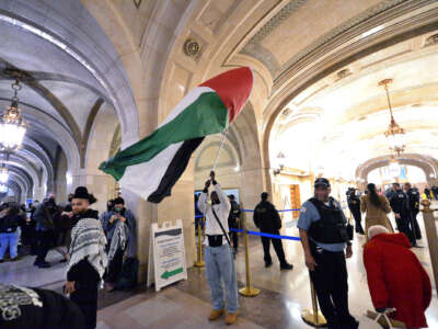 A man waves a Palestinian flag within Chicago's city hall