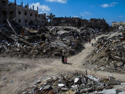 People walk past the ruins of buildings destroyed by Israeli bombardment in Jabalia refugee camp in Gaza on March 22, 2024.