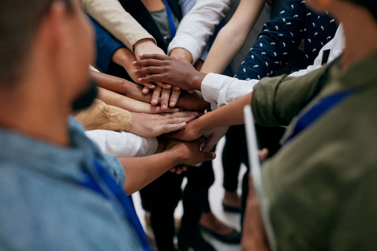 Workers join hands together