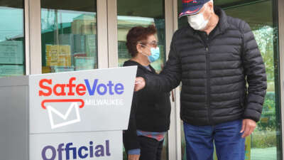 Residents drop mail-in ballots in an official ballot box outside of the Tippecanoe branch library on October 20, 2020, in Milwaukee, Wisconsin.