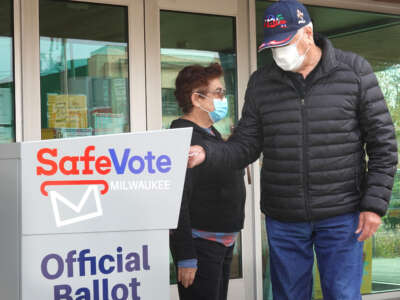Residents drop mail-in ballots in an official ballot box outside of the Tippecanoe branch library on October 20, 2020, in Milwaukee, Wisconsin.