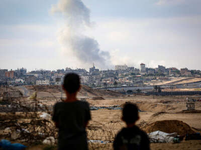 Children watch smoke billowing during Israeli strikes east of Rafah in the southern Gaza Strip on May 13, 2024.