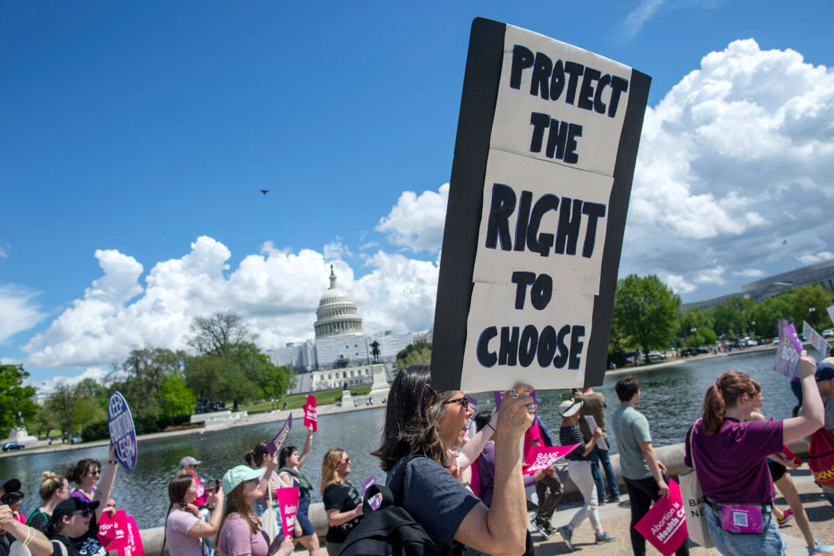 A demonstrator holds a sign reading "Protect the right to choose" during a march at the U.S. Capitol on April 15, 2023, in Washington, D.C.