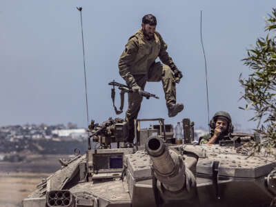 An idf soldier stomps on the roof of a tank