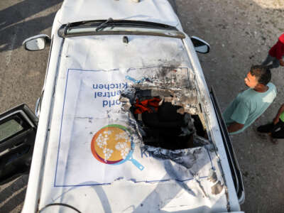 Residents inspect the damaged vehicle damaged vehicle carrying Western employees after Israeli attack in Deir al-Balah, Gaza, on April 2, 2024.