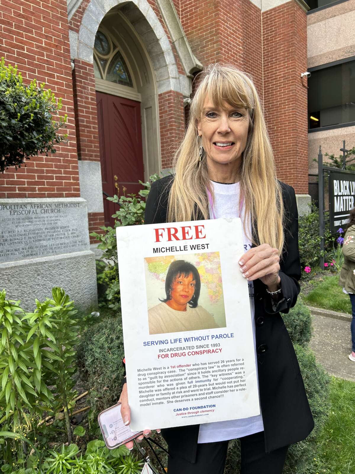 Amy Povah of CAN-Do Clemency holding a sign for Michelle West, currently serving two life sentences in federal prison for drug conspiracy. West was recently transferred from FCI Dublin, which officials abruptly closed in mid-April, to FCI Waseca in Minnesota.