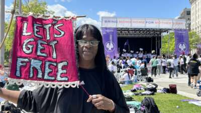 Avis Lee holds a banner for Let's Get Free, the Women and Trans Prisoner Defense Committee which helped with her fight for freedom and with which she now organizes to free others.