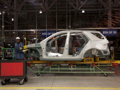 Mercedes employees work on assembly line