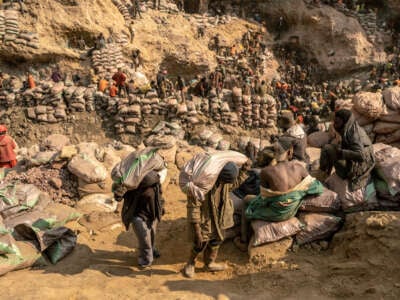 Miners carry bags of ore in the copper-cobalt Shabara artisanal mine near the town of Kolwezi, Lualaba, in the Democratic Republic of Congo, on June 20, 2023.