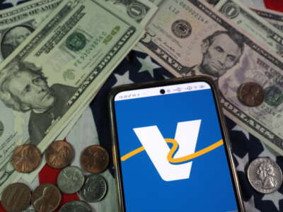 Valero Energy Corporation logo displayed on a smartphone with U.S. currency notes and coins in the background.