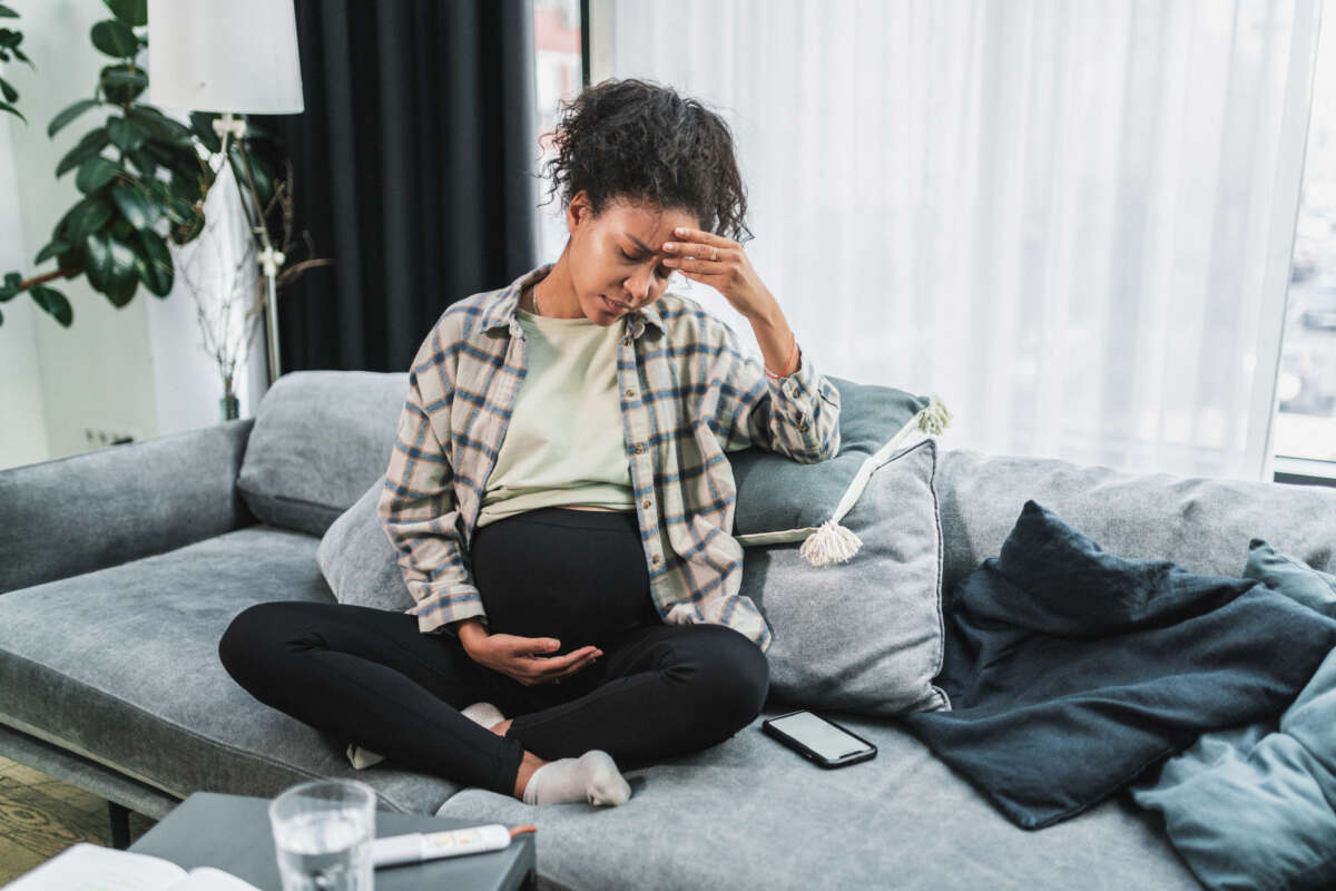 Black pregnant woman feeling tired and exhausted.