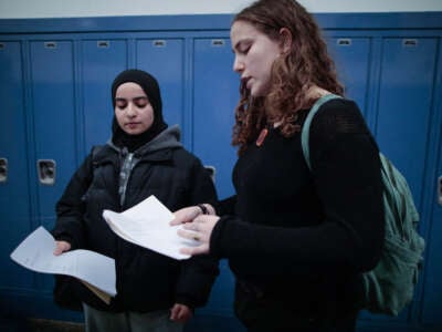 Rawda Elbatrawish (L) and Liora Pelavin organize flyers for a student dialogue at Teaneck High School in Teaneck, New Jersey, on January 19, 2024.