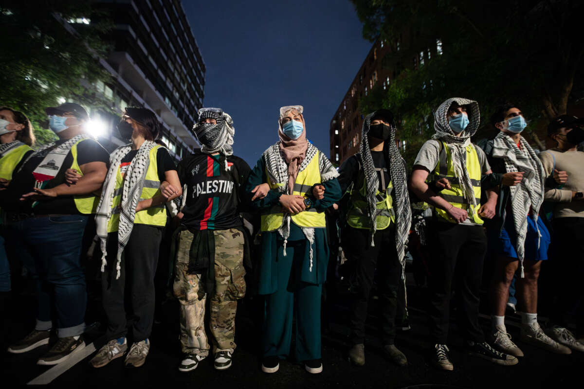 Pro-Palestinian students and their supporters form a protective chain around a temporary Gaza solidarity encampment outside the office of George Washington University president Ellen Granberg in Washington, D.C., on May 9, 2024.