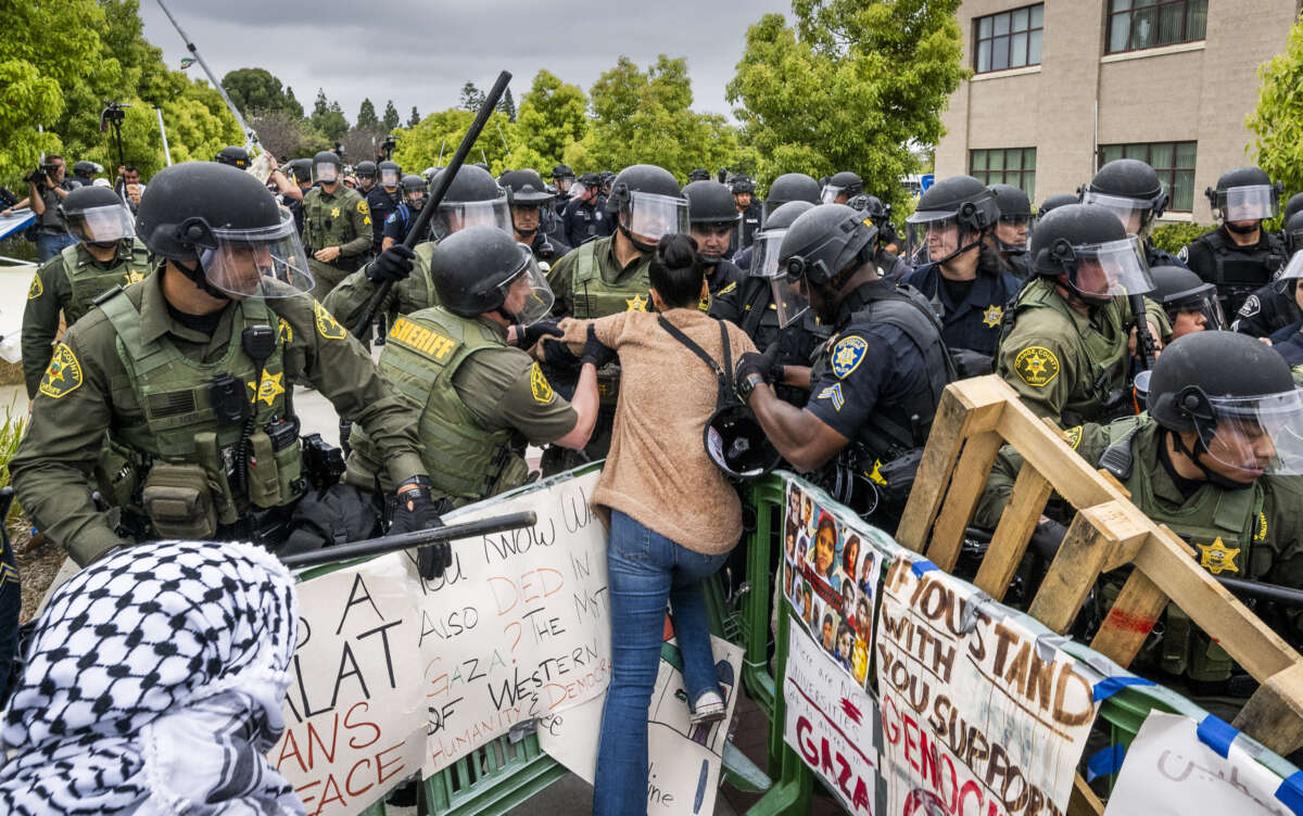 Police grab a protester as they attempt to dismantle the pro-Palestine encampment at UC Irvine in Irvine, California, on May 15, 2024.