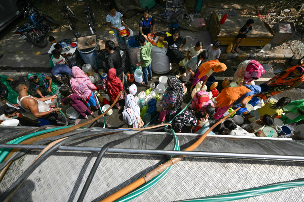 Residents fill containers with water supplied by a municipal tanker in New Delhi, India, on May 30, 2024, amid an ongoing heat wave.