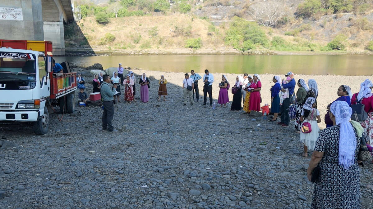 Members of a local church hold a service for a baptism of a little girl on the banks of the Lempa River in El Salvador.