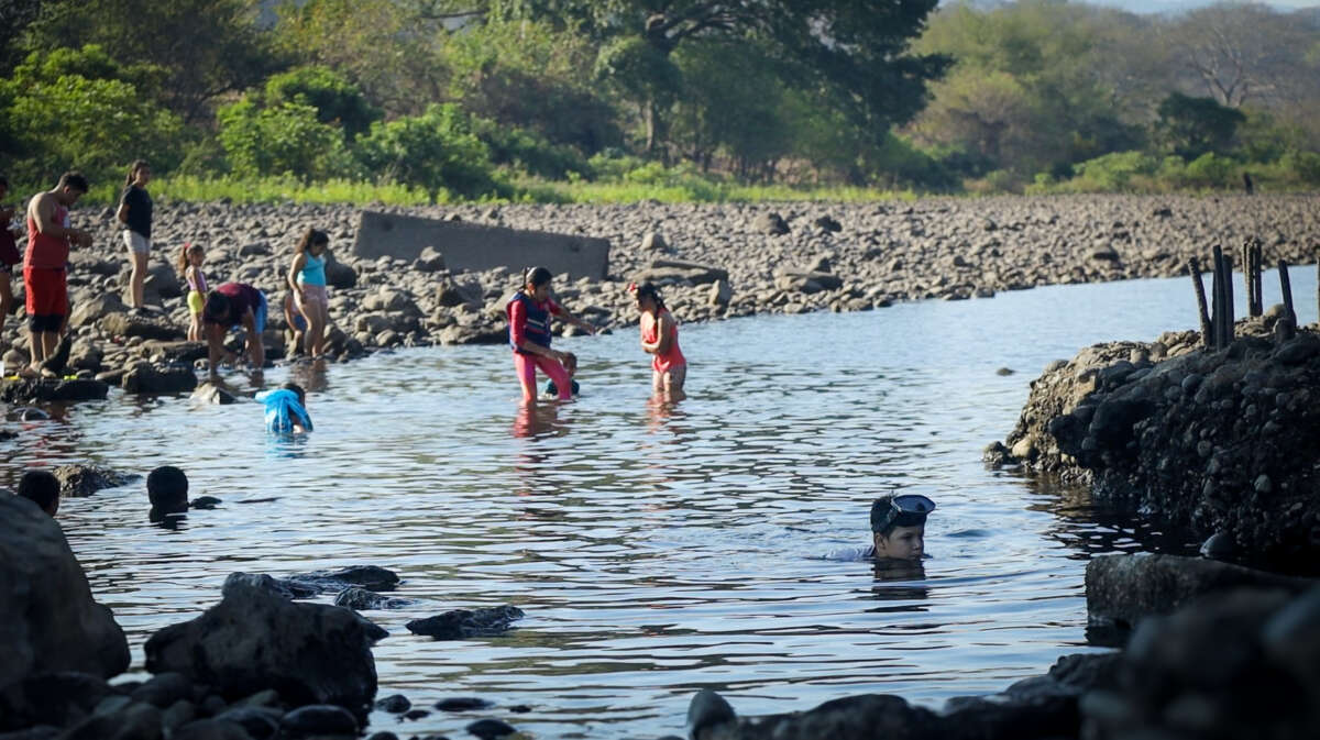 Children play in the Lempa River, under the Cuscatlan Bridge in El Salvador.