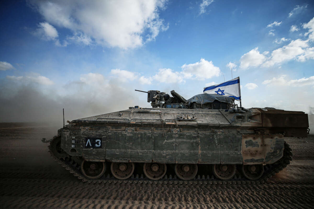 An Israeli tank is shown driving through the desert