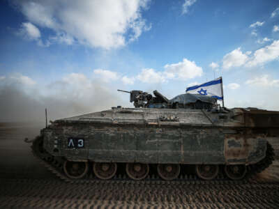 An Israeli tank is shown driving through the desert