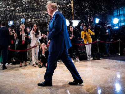 Donald Trump walks past reporters