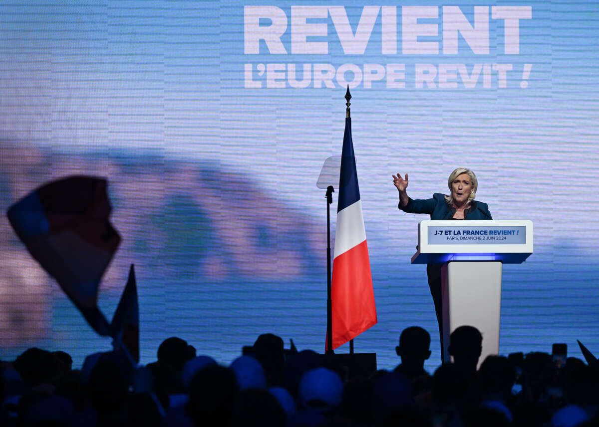 Marie Le Pen speaks to an audience from a podium