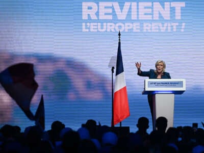 Marie Le Pen speaks to an audience from a podium