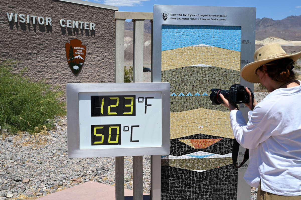 A woman takes a photo of thermometer that shows 123 Fahrenheit (50 C) at the Furnace Creek Visitor Center in Death Valley today as extreme heat wave warming issued in California on June 6, 2024.