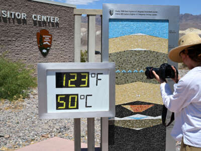 A woman takes a photo of thermometer that shows 123 Fahrenheit (50 C) at the Furnace Creek Visitor Center in Death Valley today as extreme heat wave warming issued in California on June 6, 2024.